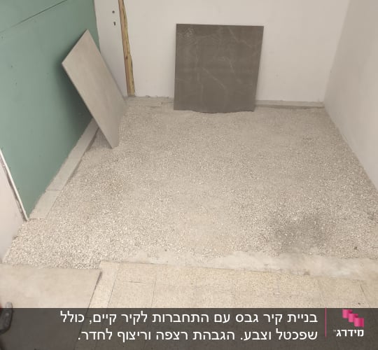 חדר עם רצפה בתהליך ריצוף ואריחים מונחים